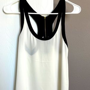 Express tank top in an off white with black straps and gold zipper detail.